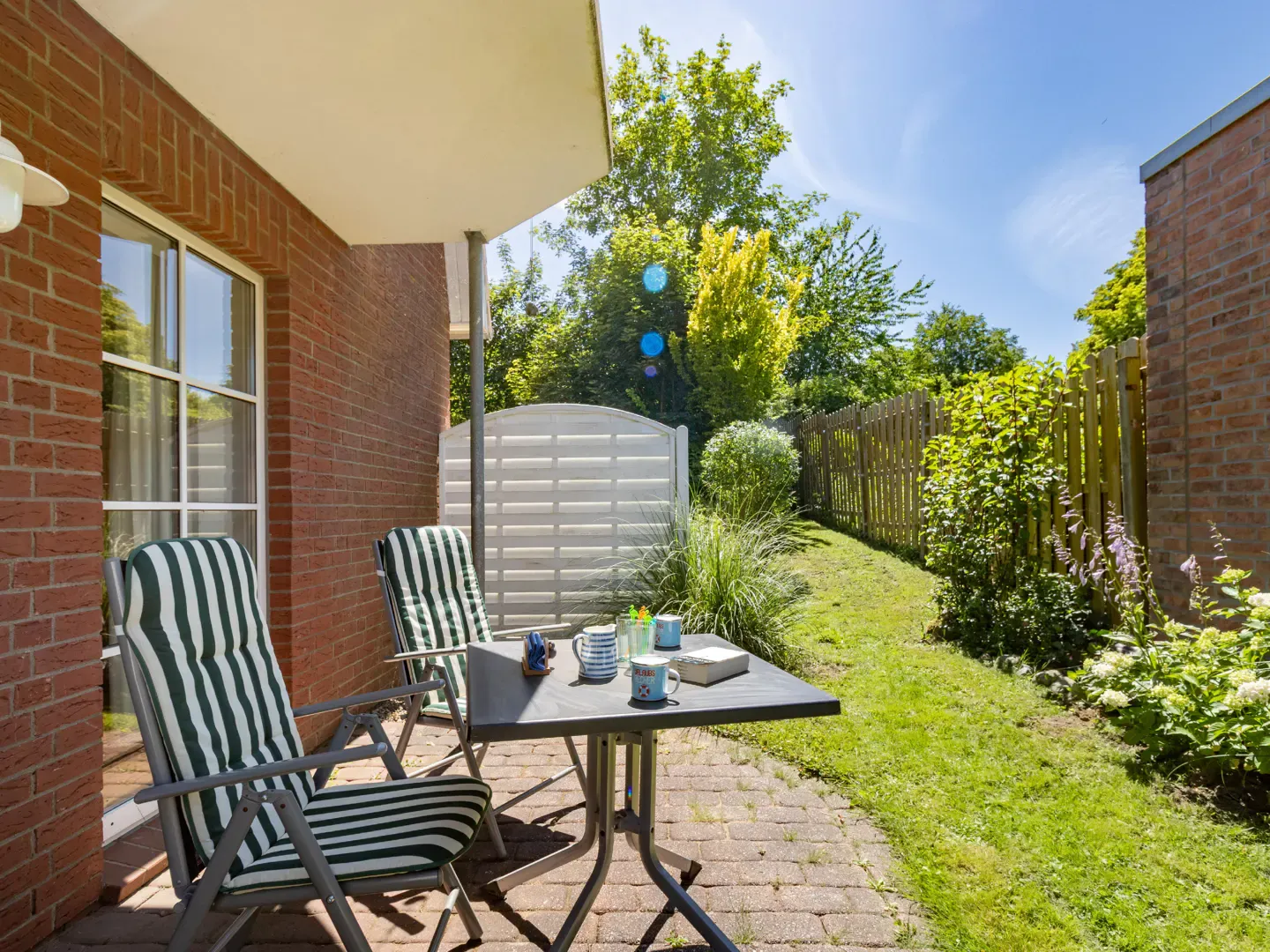 Ferienwohnung Matthias in Schönhagen an der Ostsee – Blick auf die sonnige Terrasse und den Garten in Brodersby-Schönhagen